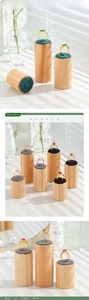 Close-up of golden gemstone rings on cylindrical wooden displays with velvet slots