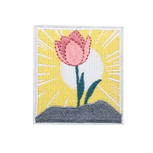 Square embroidered patch featuring pink tulips and a yellow sunburst on a gray base