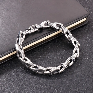 Detailed close-up of textured stainless steel curb chain bracelet on a black background