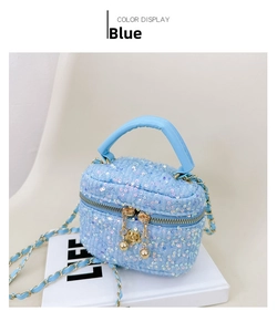 Detail of blue sequin mini vanity bag featuring a gold chain and rose zipper puller