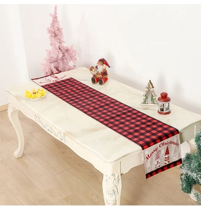 Close-up of red and black buffalo plaid Christmas table runner on white marble surface