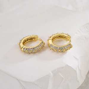 Detailed close-up of 18K gold-plated hoop earrings with cubic zirconia and spike accents