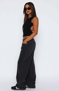 Detail of the high-waisted charcoal grey wide-leg jeans with clean stitching and draping