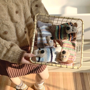 Close-up of fluffy coral fleece socks with 3D cartoon dog ears and striped patterns