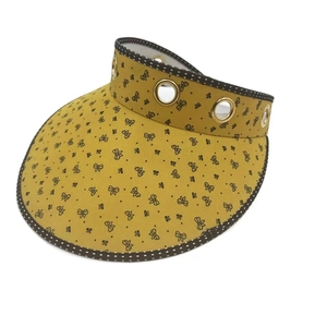 Detail of yellow sun visor with butterfly print, metal eyelets and polka dot piping