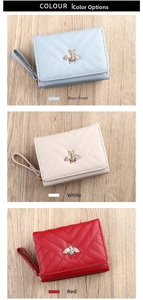Close-up of V-quilted women's wallets with bee metal decor in blue, white, and red