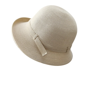 Close-up of elegant beige straw sun hat featuring fine weaving texture and wavy brim detail