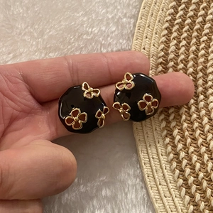 Runde schwarze Emaille-Ohrstecker mit goldenem Blumenmuster im edlen Vintage-Stil