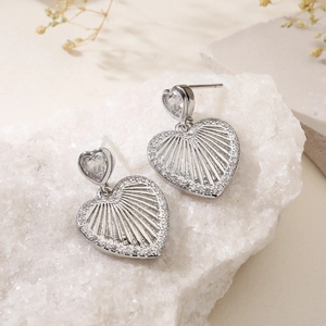 Minimalist silver heart earrings with sparkling zircon on natural white stone base