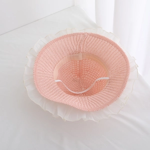 Pink woven straw sun hat for baby girls with white chiffon ruffle trim and elastic strap