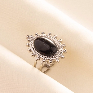 Dettaglio di un anello in acciaio inossidabile con pietra nera e finiture vintage