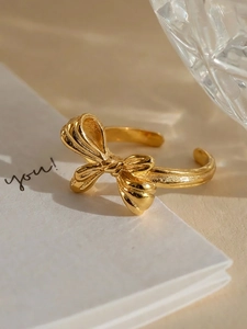 Detailed macro view of PVD gold plated bow ring with matte and polished texture