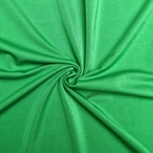 Close-up of green knitted fabric texture with a soft sheen for slim fitting long dresses