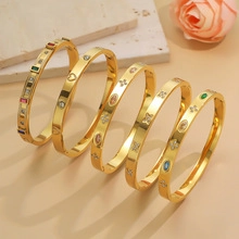 Detailed view of gold plated stainless steel bracelets with crystals and clover charms