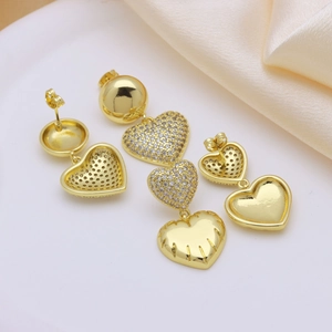 Elegant gold heart earrings with pave cubic zirconia on a soft silk background