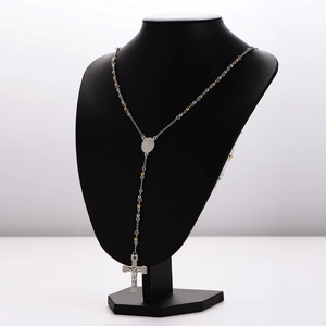 Silver and gold stainless steel rosary necklace with crucifix pendant on black bust