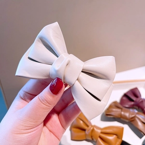 Détail de barrettes nœud en similicuir style français rétro en crème et marron
