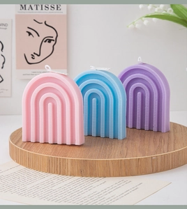 Arch rainbow scented candles in pink blue and purple on a wooden tray with artistic decor