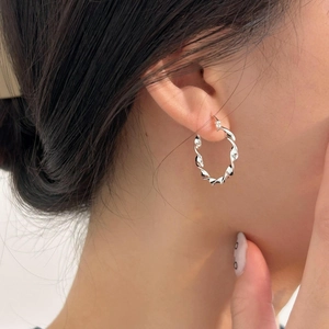 Close-up of model wearing 925 sterling silver twisted rope hoop earrings in silver