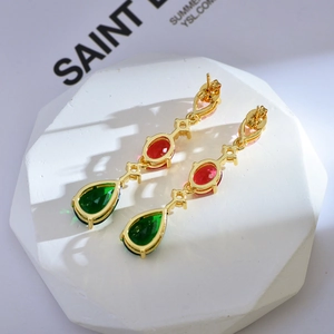 Detailed shot of teardrop-shaped luxury crystal earrings with red and green gemstones