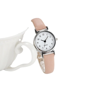 Elegant women's quartz watch with pink leather strap and white dial on a display stand