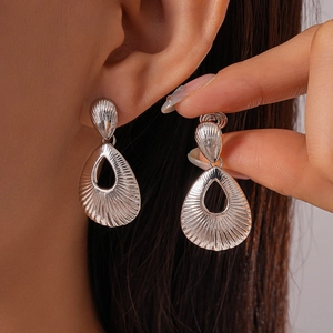 Detail shot of silver hollow teardrop earrings with embossed radial metallic texture
