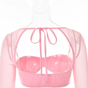 Détail du haut rose à manches longues en mesh avec laçage au dos sur un mannequin de studio