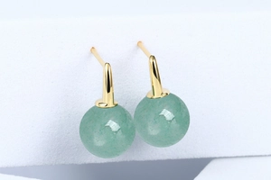 Macro detail of natural green aventurine beads on gold-plated S925 silver hook earrings