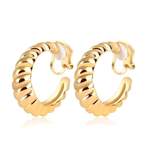 Close-up of golden geometric twisted clip-on earrings with white comfort pads