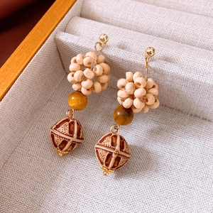 Macro shot of bohemian wood bead earrings with geometric patterns in a jewelry box