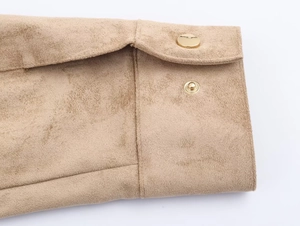Detailed macro view of the khaki faux suede fabric texture and gold metal snap button closure