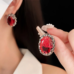 Detailed close-up of vintage oval red gemstone earring with elegant metallic inlay