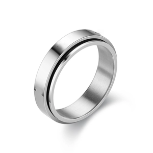 Detailed close-up of a silver spinner ring with a brushed finish and black groove design