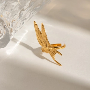 Macro detail of golden peace dove ring showing intricate feather relief on metal surface