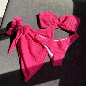 Detailed view of hot pink crinkle fabric bikini set with matching tie-front sarong