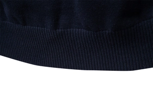 Dettaglio dell'orlo a costine blu navy su questo maglione in maglia di cotone da uomo