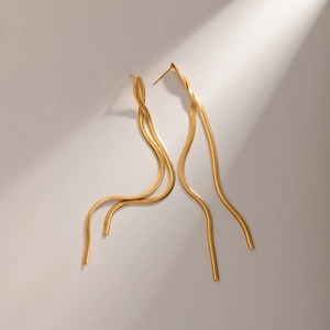 Detailed view of long gold tassel earrings with dual snake chain design and sleek finish