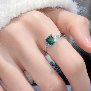 Elegant emerald cut green zircon ring with sparkling side stones in silver open band design
