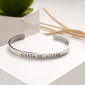 Adjustable stainless steel open bangle with engraved 'little sister' and heart symbol