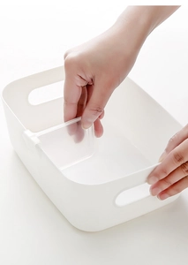 Detail showing hands installing transparent dividers in a white plastic fridge storage box