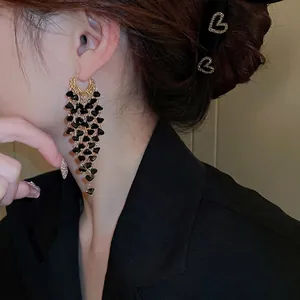 Elegant gold earrings with layered black heart crystals in a fringe tassel design