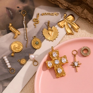 Detailed view of 18K gold plated vintage pendants with bow, heart, and pearl charms