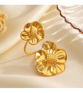 Detailed view of 18K gold plated stainless steel chunky floral ring on beige silk fabric
