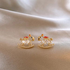 Close-up of 18K gold plated rocking horse earrings with cubic zirconia and red enamel detail