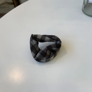 Close-up of a classic grey plaid checkered scrunchie made of soft textile fabric