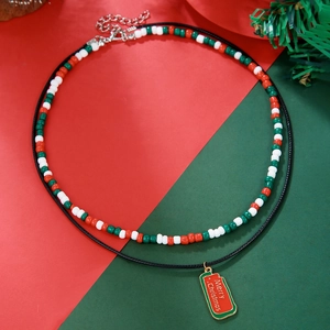 Detail of double-layer beaded necklace with Merry Christmas pendant and red seed beads