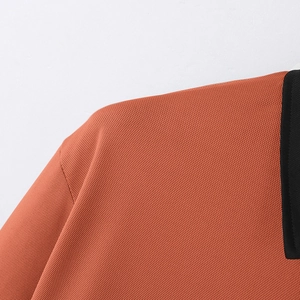 Detail shot of breathable honeycomb texture on men's polo shirt in orange and black