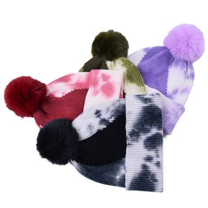 Winter tie-dye knit beanie hats with fluffy pom-poms in various colors for outdoor warmth