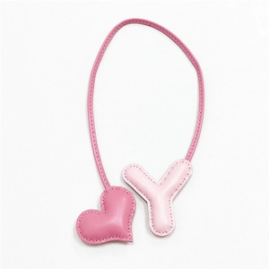 Dettaglio del ciondolo per borsa in pelle con cuore rosa e lettera Y fatta a mano