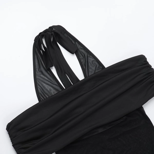 Detail eines schulterfreien Kleides mit schwarzem Netzstoff und gerafftem Design
